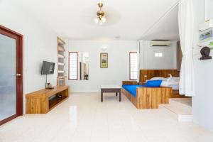 a living room with a bed and a tv at Nitchanan Villa in Hinkong