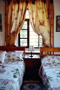 a bedroom with two beds and a window at Guest House Vasili in Berat