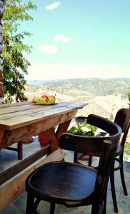 a wooden table with a chair and a table with fruit at Guest House Vasili in Berat