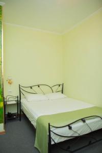 コムソモリスク・ナ・アムーレにあるZolotaia Liliaのベッドルーム(緑のシーツを使用した大きな白いベッド付)