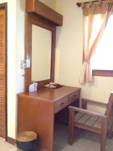 a wooden dressing table with a mirror and a chair at Phuwadee Resort in Thong Nai Pan Noi