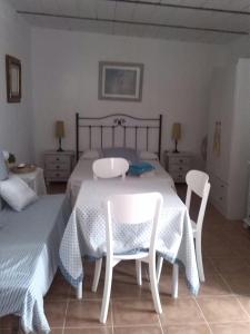 1 dormitorio con 1 cama con 2 sillas y 1 mesa en La posada en Chiclana de la Frontera