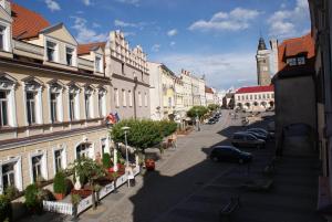 eine Stadtstraße mit Gebäuden und einem Uhrturm in der Unterkunft U koloběžky Apartment in Slavonice