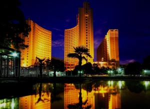 a city skyline with tall buildings and a palm tree at Wudang International Hotel in Shiyan