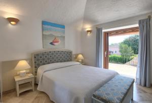 a bedroom with a bed and a large window at Hotel Nibaru in Porto Cervo