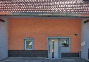 a orange building with two windows and a door at Apartment Pod velbi in Ljubljana