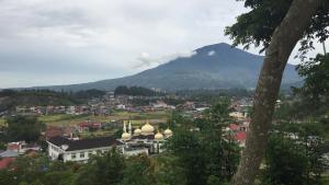 Una vista de una ciudad con una montaña al fondo. en Astani Family Home, en Bukittinggi