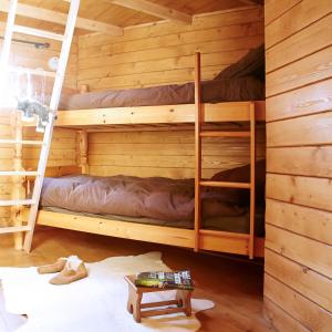 ein Schlafzimmer mit Etagenbetten in einem Blockhaus in der Unterkunft La Cab'Ane in Saint-Jean-aux-Bois