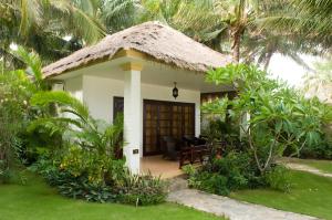 una pequeña casa con techo de paja en Cham Villas Resort en Mui Ne