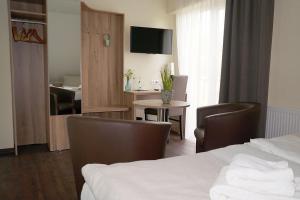 オスナブリュックにあるHotel Restaurant Huxmühleのベッド、テーブル、椅子が備わるホテルルームです。