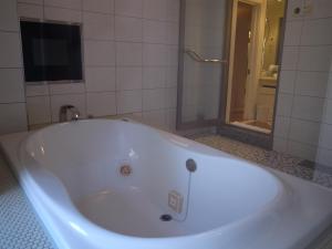 a white bath tub in a bathroom with a shower at Hotel Large (Adult Only) in Honjo