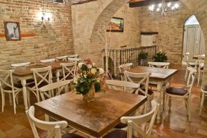 a room with tables and chairs and a brick wall at Villa Funari Country House in Servigliano
