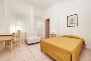 1 dormitorio con cama, escritorio y silla en Hotel Villa Orizzonte, en Malcesine