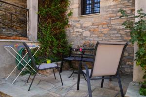 two chairs and a table in front of a building at Villa Kotronia in Afissos