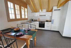 a kitchen with a table and chairs in a room at Charming Penthouse in Lauterbrunnen