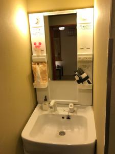 
a bathroom with a sink and a mirror at Khaosan Tokyo Kabuki in Tokyo
