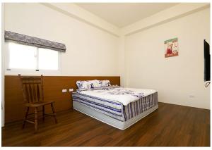 台東市的住宿－筆令莊園，卧室配有床、椅子和窗户。