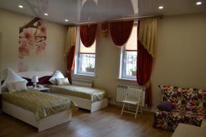 キルジャチにあるGuest House Admyralskie Banyのベッドルーム1室(ベッド2台、ソファ、窓付)