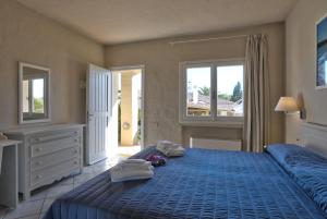 a bedroom with a blue bed with towels on it at Hotel Nibaru in Porto Cervo
