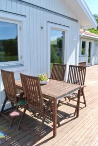 drewniany stół i 4 krzesła na tarasie w obiekcie Room by Water w mieście Södertälje