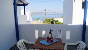 una mesa con una botella de vino en el balcón en Studios Vagos 1, en Agios Prokopios