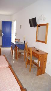 sala de estar con mesa, sillas y TV en Studios Vagos 1, en Agios Prokopios