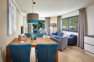 uma sala de estar com uma mesa e cadeiras azuis em Kristall Plaza em Niederau