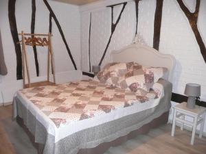 una camera da letto con un letto con una trapunta sopra di Rose Cottage En Baie De Somme a Nouvion-en-Ponthieu
