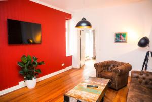ein Wohnzimmer mit einer roten Wand, einem Sofa und einem Tisch in der Unterkunft Uferpromenade in Waren (Müritz)