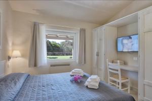 a bedroom with a bed with towels and a window at Hotel Nibaru in Porto Cervo