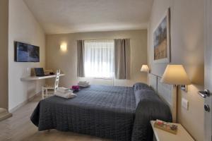 a hotel room with a bed and a window at Hotel Nibaru in Porto Cervo