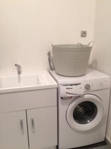 a washing machine with a bucket on top of it at La Maison Bellevue in Saint-Efflam