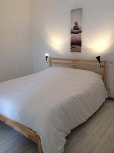 a bed with white sheets on it in a room at La Maison Bellevue in Saint-Efflam