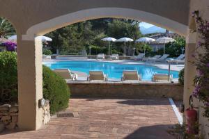 a swimming pool with chairs and umbrellas at Hotel Nibaru in Porto Cervo