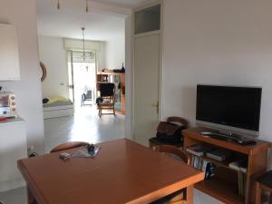 a living room with a table and a television at Appartamento Gentile in Torre dell'Orso