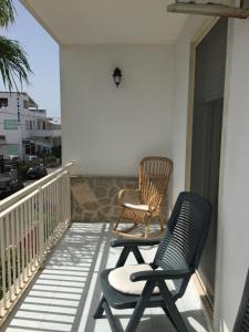 two chairs sitting on the balcony of a house at Appartamento Gentile in Torre dell'Orso