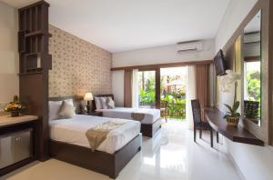 a hotel room with two beds and a balcony at Grand Sehati & Spa, Ubud in Ubud