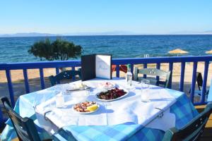 a table with a plate of food on the beach at Aiolos in Vaia