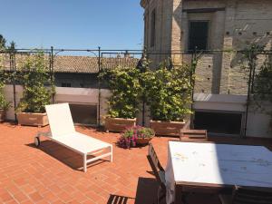 a white chair and a table on a brick patio at B&b Piazzetta in Fermo