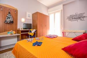 a bedroom with a large orange bed with clothes on it at Hotel Tritone Rimini in Rimini