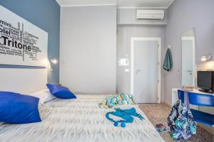 a bedroom with a bed with blue pillows at Hotel Tritone Rimini in Rimini