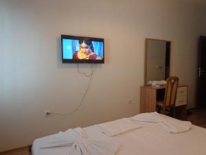einen Fernseher, der an einer Wand in einem Schlafzimmer hängt in der Unterkunft Hotel Rio in Pristina