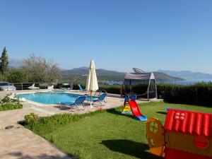 podwórko z basenem i placem zabaw w obiekcie Stelios Apartments w mieście Istro