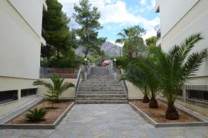a stairway leading up to a building with palm trees at Kineta Apartments in Kineta