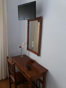 een houten tafel met een televisie bovenop een spiegel bij Pensión Vázquez in Vimianzo
