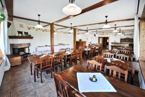 a restaurant with wooden tables and chairs and a fireplace at APLEND Villas Tatry Holiday in Veľký Slavkov