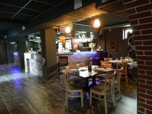 ein Speisesaal mit Tischen und Stühlen und einer Bar in der Unterkunft Liador in Câmpia Turzii