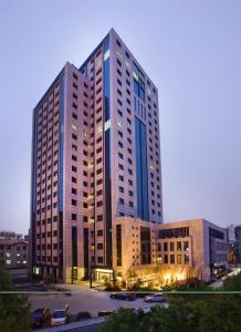 a tall building with many windows in a city at SSAW Boutique Hotel Nanchang Bayi Square in Nanchang