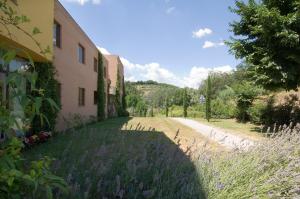 a building with purple flowers next to a road at Hotel Palazzo dei Priori in Siena