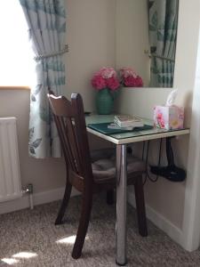 a desk with a chair and a table with flowers at Gentian Villa B&B in Ballyvaughan